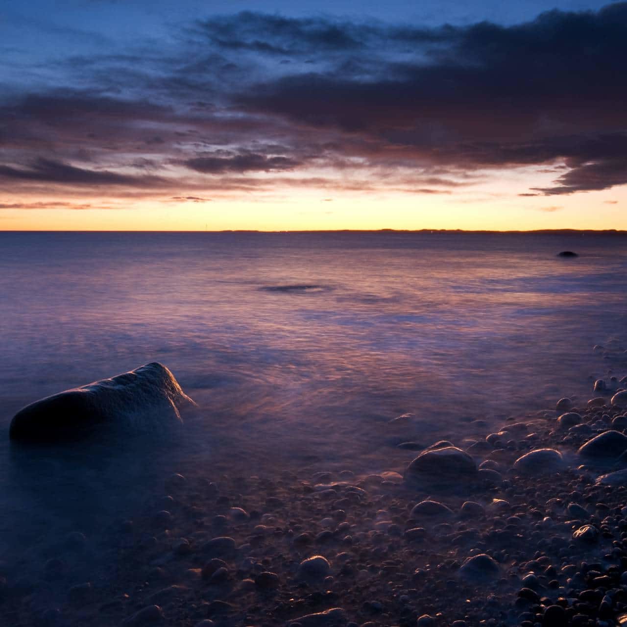 Sunset above the pebble beach of Mølen